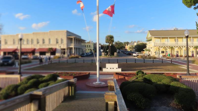 Waterfront park and flagpole at the foot of downtown St. Marys, Georgia, with two-story historic buildings along the street