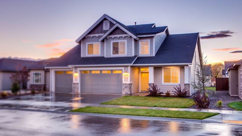 Two-story suburban home at dusk after rain, with K-style gutters running along each eave