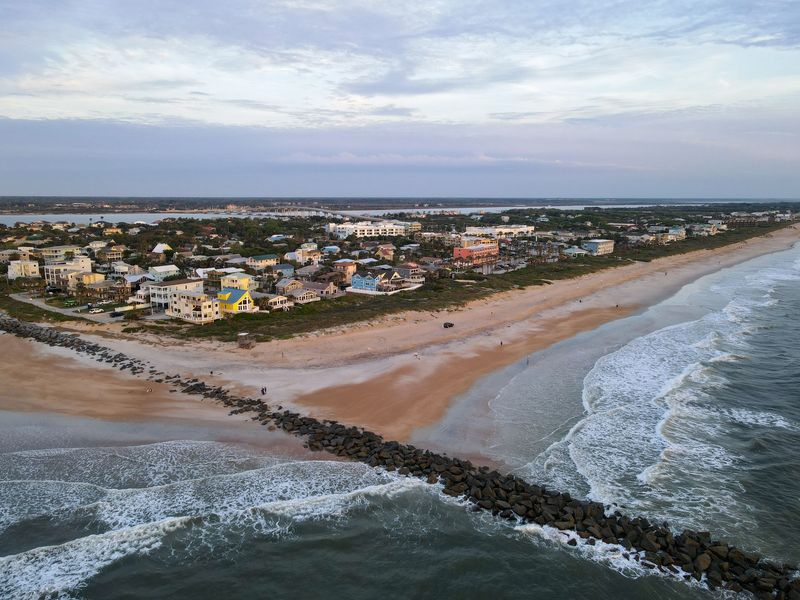 Aerial view of beach houses behind the dunes beside a rock jetty and the Atlantic Ocean near St. Augustine